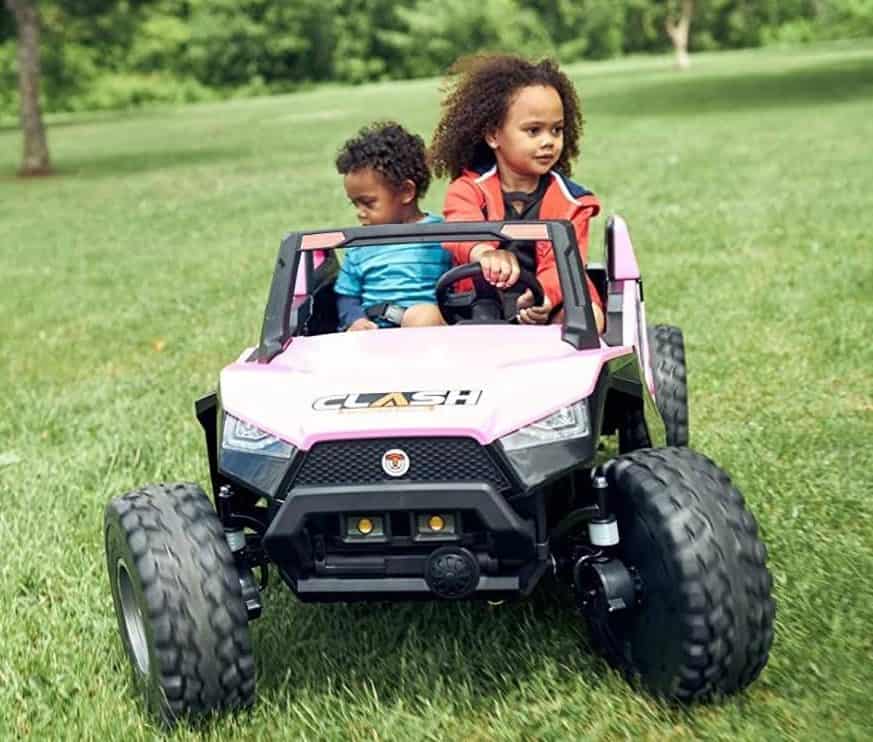 صورة طفلين يستمتعون بركوب السيارة الكهربائية